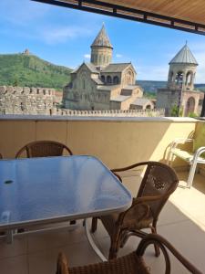 a table and chairs on a balcony with a view of a castle at Old Capital in Mtskheta