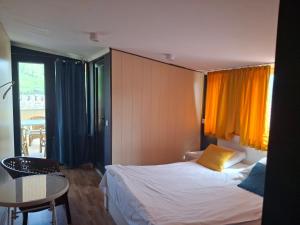 a bedroom with a bed and a table and a window at Old Capital in Mtskheta