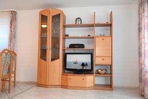 a wooden entertainment center with a television in a room at Bernstein Mare-Comfort Wohnung 5 in Büsum +3 photos