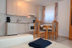 a kitchen with a table and chairs and a kitchen with a sink at Bernstein Mare-Comfort Wohnung 5 in Büsum