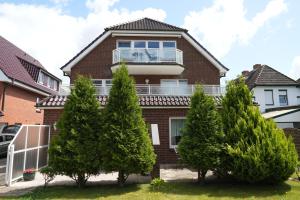 a brick house with trees in front of it at Bernstein Mare-Comfort Wohnung 5 in Büsum
