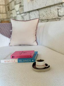 a pile of books and a cup of coffee on a bed at Moranka by ALS ALAÇATI in Alaçatı