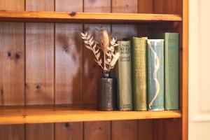 a book shelf with books and a vase with a plant at Alnwick 2 Bed Cottage Stay, Joe's Cottage in Alnwick