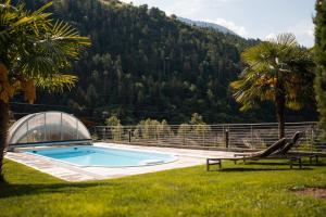 a swimming pool in a yard with a greenhouse at Chalet Resort Innerluferhof in Rifiano