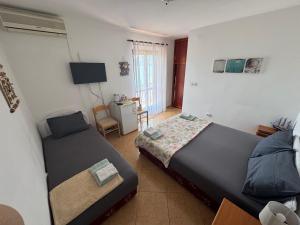 a bedroom with two beds and a chair in it at Casa Julia in Herceg-Novi