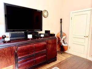 a living room with a flat screen tv and a guitar at Villa Del Mar in Jūrmala