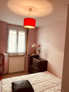 a bedroom with a bed and a red lamp at Les Volets Blancs in Étaples +2 photos