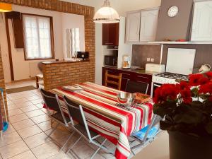 a kitchen with a table with a table cloth on it at Les Volets Blancs in Étaples
