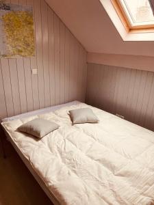 a bed in a room with two pillows on it at Les Volets Blancs in Étaples