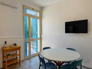 a dining room with a table and chairs and a tv at Veranda sul mare di Donnalucata in Donnalucata