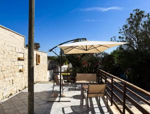 a table and chairs under an umbrella on a patio at Veranda sul mare di Donnalucata in Donnalucata