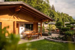 a wooden house with a table and chairs in a yard at Chalet Resort Innerluferhof in Rifiano