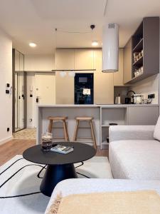 a living room with a table and a kitchen at Mavrin Home Zagreb, free parking, 3,8km from Old Town, Breakfast in Zagreb