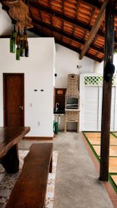 a living room with a wooden bench and a table at Casa 3 amores PREÁ, vento, charme, piscina e 2 quartos in Prea