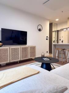 a living room with a large tv and a table at Mavrin Home Zagreb, free parking, 3,8km from Old Town, Breakfast in Zagreb