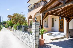 a house with a porch and a stone wall at Philoxenia Hotel in Skala Prinou