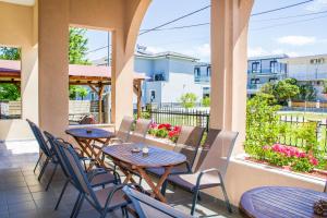 a patio with tables and chairs on a balcony at Philoxenia Hotel in Skala Prinou