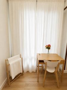 a dining room table with a vase of flowers and a window at Letras del Tormes in Salamanca