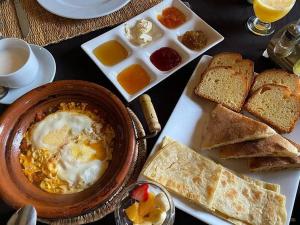 a breakfast table with a bowl of eggs and bread at Unique Luxury Camp in Merzouga
