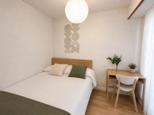 a small bedroom with a bed and a desk at Letras del Tormes in Salamanca