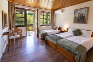 a bedroom with two beds and a table and chairs at Bashtinata stryaha Guest rooms and Natural pool in Beli Osŭm +68 photos