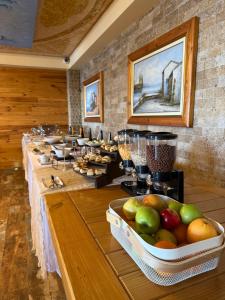 a row of tables in a room with fruit in a tray at Suites Castello in Bar