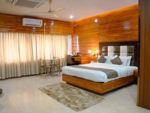 a bedroom with a bed and a table and a desk at Donyi Polo International in Itānagar