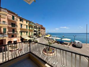 a balcony with a view of a street and the ocean at Casa Piazza dei Rioni in Porto Santo Stefano