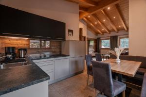 a kitchen with a wooden table and a dining room at Chalet Resort Innerluferhof in Rifiano