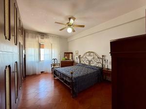 a bedroom with a bed and a ceiling fan at Casa Piazza dei Rioni in Porto Santo Stefano