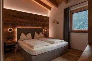 a bedroom with a large bed with a window at Chalet Resort Innerluferhof in Rifiano