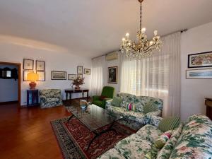 a living room with a couch and a chandelier at Casa Piazza dei Rioni in Porto Santo Stefano