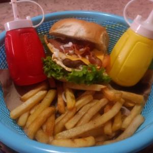 a blue basket with a sandwich and french fries and a drink at Backpack Cabin A 49149 in Oranjestad