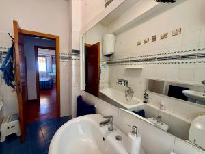a bathroom with a white sink and a mirror at Casa Piazza dei Rioni in Porto Santo Stefano +23 photos