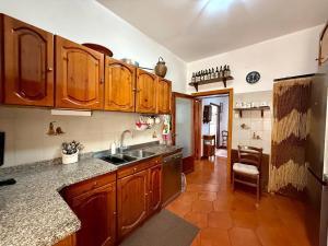 a kitchen with wooden cabinets and a sink at Casa Piazza dei Rioni in Porto Santo Stefano