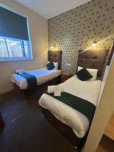 a hotel room with two beds and a window at The Moseley Arms in Birmingham