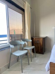 three chairs in a room with a window at The City View Homestay in Srīnagar