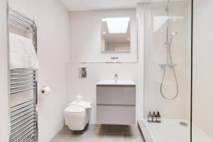 a white bathroom with a shower and a toilet at Northern Hideaways, Iona Cottage in Newcastle upon Tyne
