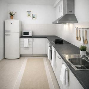 a white kitchen with a sink and a refrigerator at Rincon de Paz in Corralejo