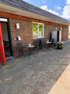 a patio with tables and chairs next to a brick building at Room for rent Solskrænten in Vorgod