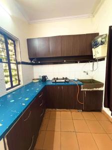 a kitchen with a blue counter top with a sink at The pink house in Jaipur