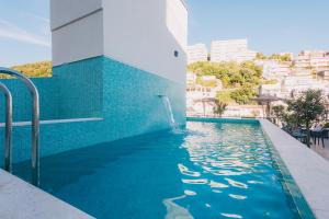 a swimming pool with a water fountain next to a building at Atelier in Ulcinj
