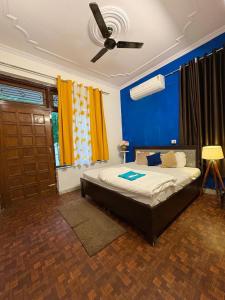 a bedroom with a bed with a ceiling fan at The pink house in Jaipur