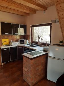 a kitchen with a white refrigerator and a brick wall at Mariolka Skorzęcin in Skorzęcin