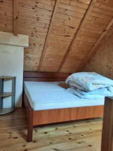 a bed in a room with a wooden ceiling at Mariolka Skorzęcin in Skorzęcin