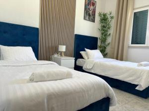 two beds in a bedroom with blue and white at ABRA residence alverca in Quinta da Verdelha