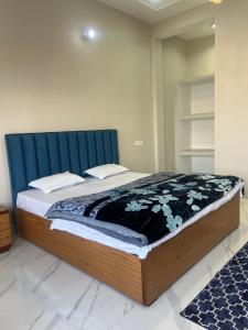 a large bed with a blue headboard in a room at The City View Homestay in Srīnagar