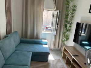 a living room with a blue couch and a television at ABRA residence alverca in Quinta da Verdelha