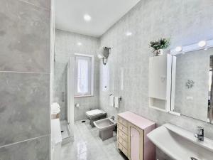 a bathroom with a sink and a toilet and a mirror at Casa Aurora in Ravello