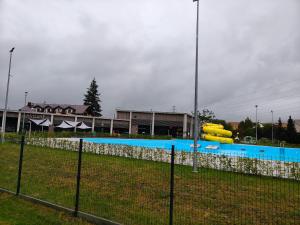 a fence in front of a swimming pool with yellow cylinders at Promenada in Węgierska Górka